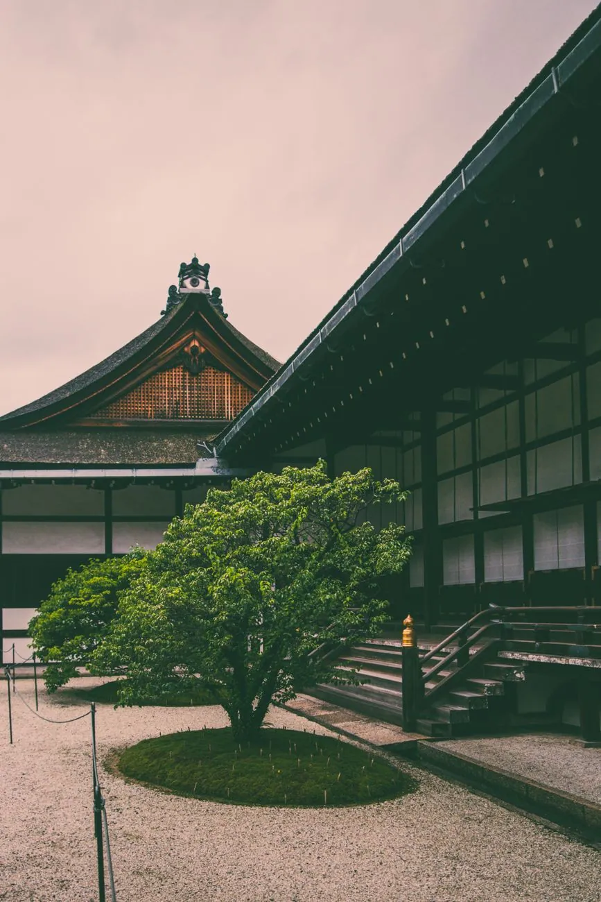 A traditional Japanese temple courtyard in Kyoto with lush greenery