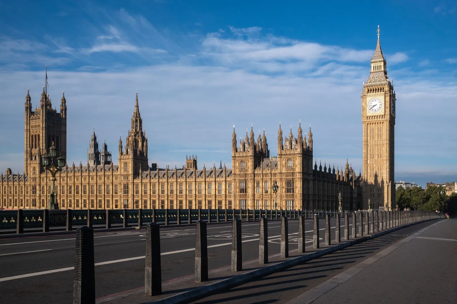 Iconic view of Big Ben and the Palace of Westminster in London, UK, under a blue sky.