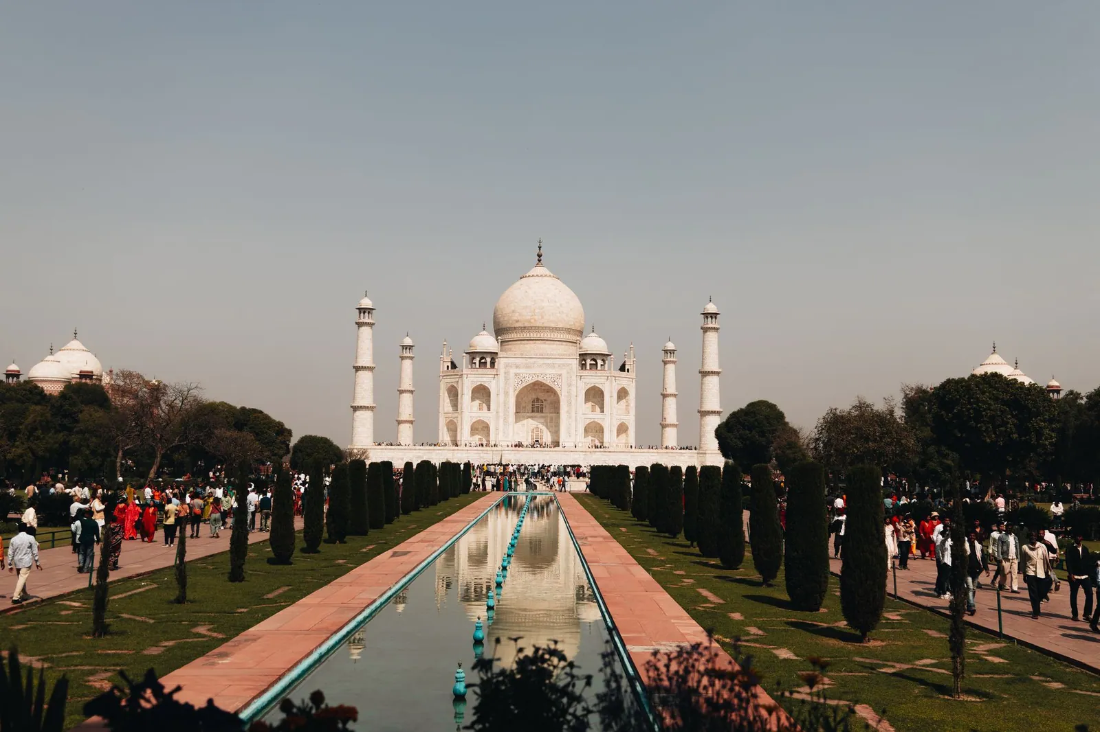 A beautiful view of the Taj Mahal with visitors and reflection in Agra, India