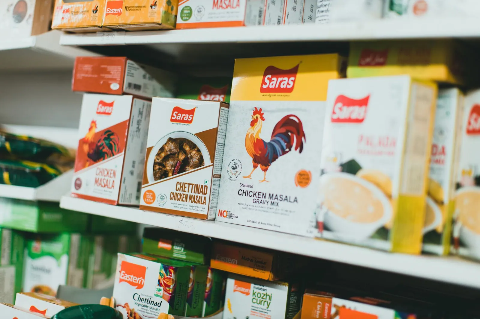 Assortment of Indian spice mixes on a grocery store shelf, featuring colorful packaging.