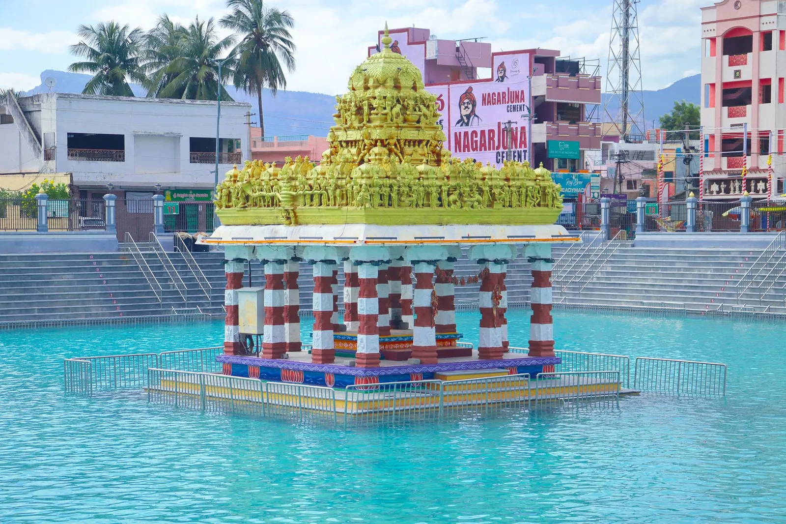 Colorful temple pavilion in a reflecting pool with traditional architecture.