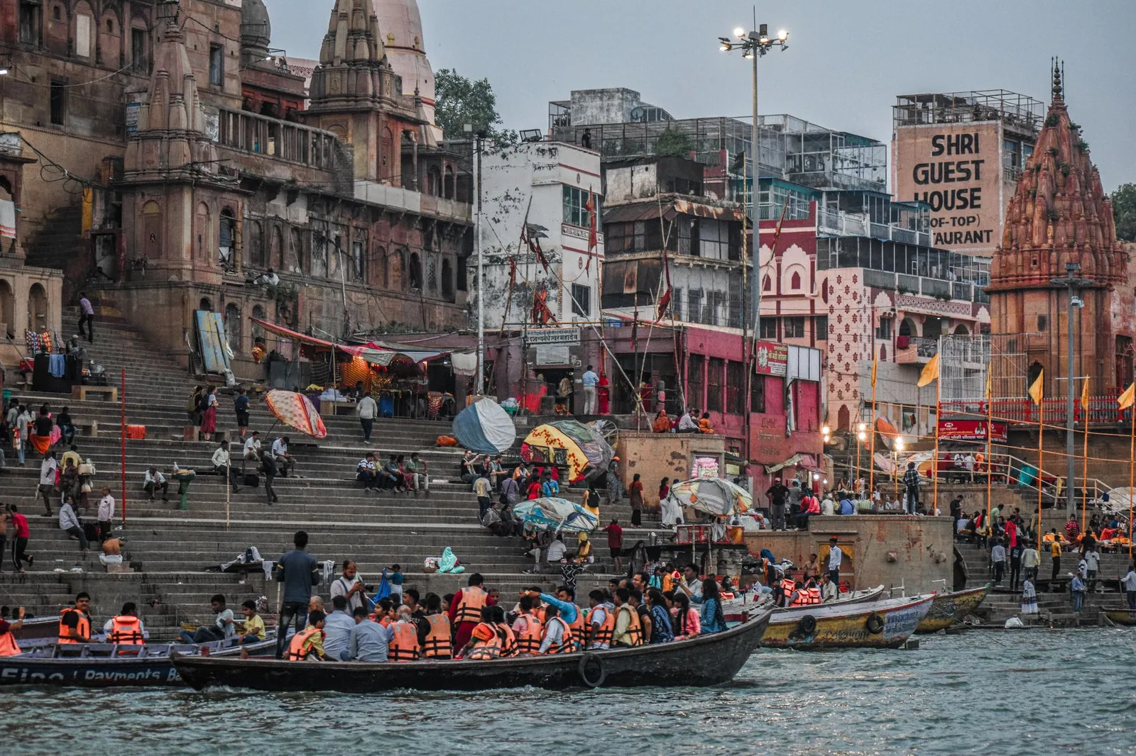Lively scene of boats and people along the Ganges riverfront in Varanasi, India