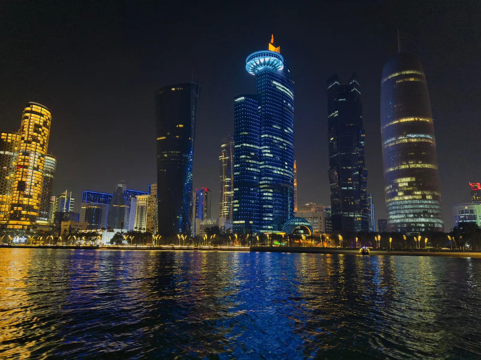 Night scene of Doha's illuminated skyline reflecting on water in Qatar