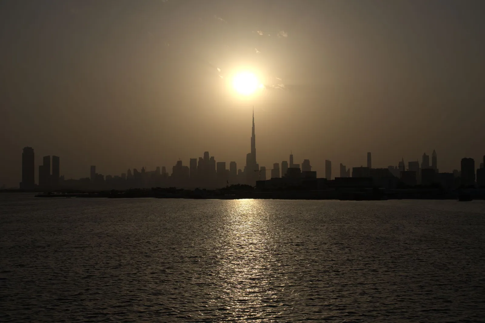Captivating sunset view of Dubai skyline featuring Burj Khalifa silhouetted against the sky.