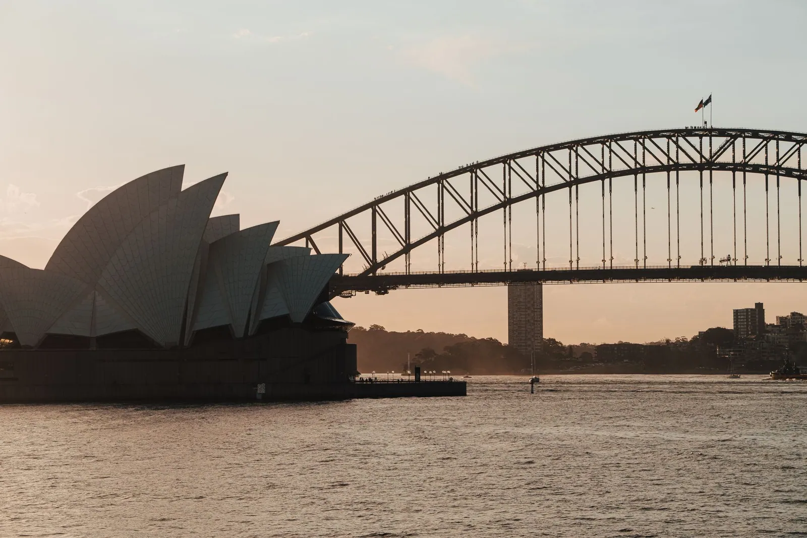 A scenic view of Sydney Opera House and Harbour Bridge at dusk, captured on a tranquil evening.