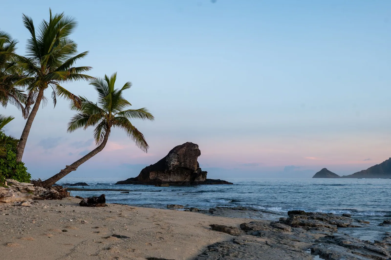 Tropical beach with palm trees at sunrise on Kuata Island, Fiji
