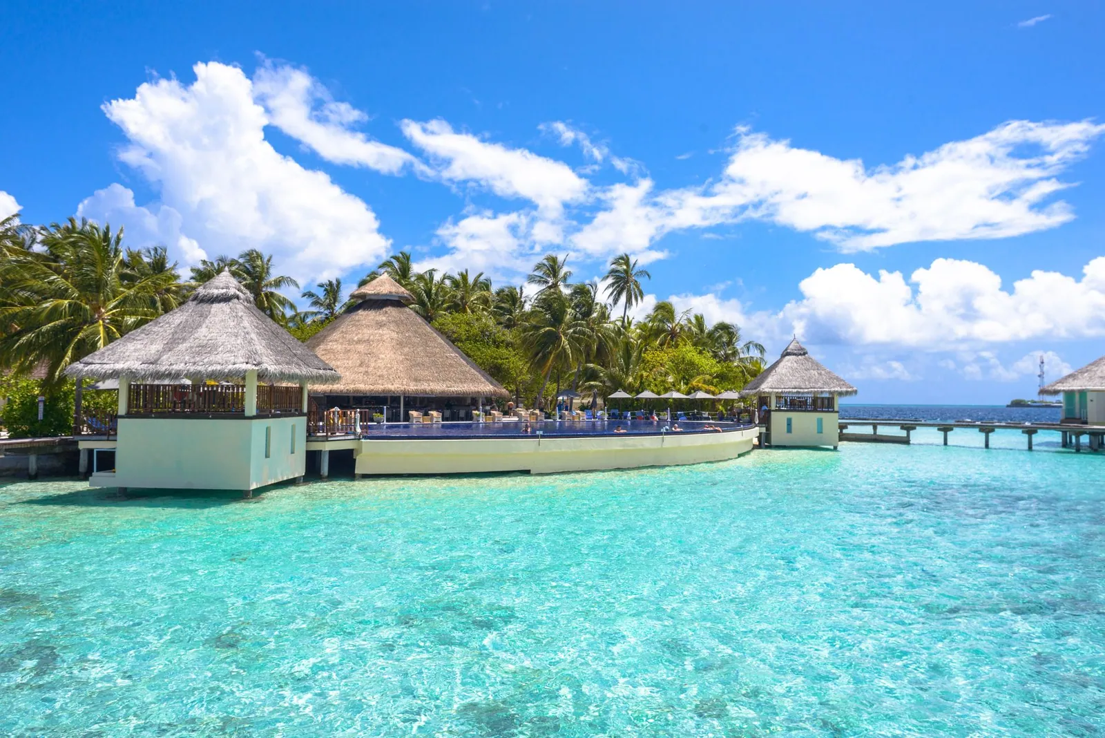 Overwater resort bungalows surrounded by turquoise sea