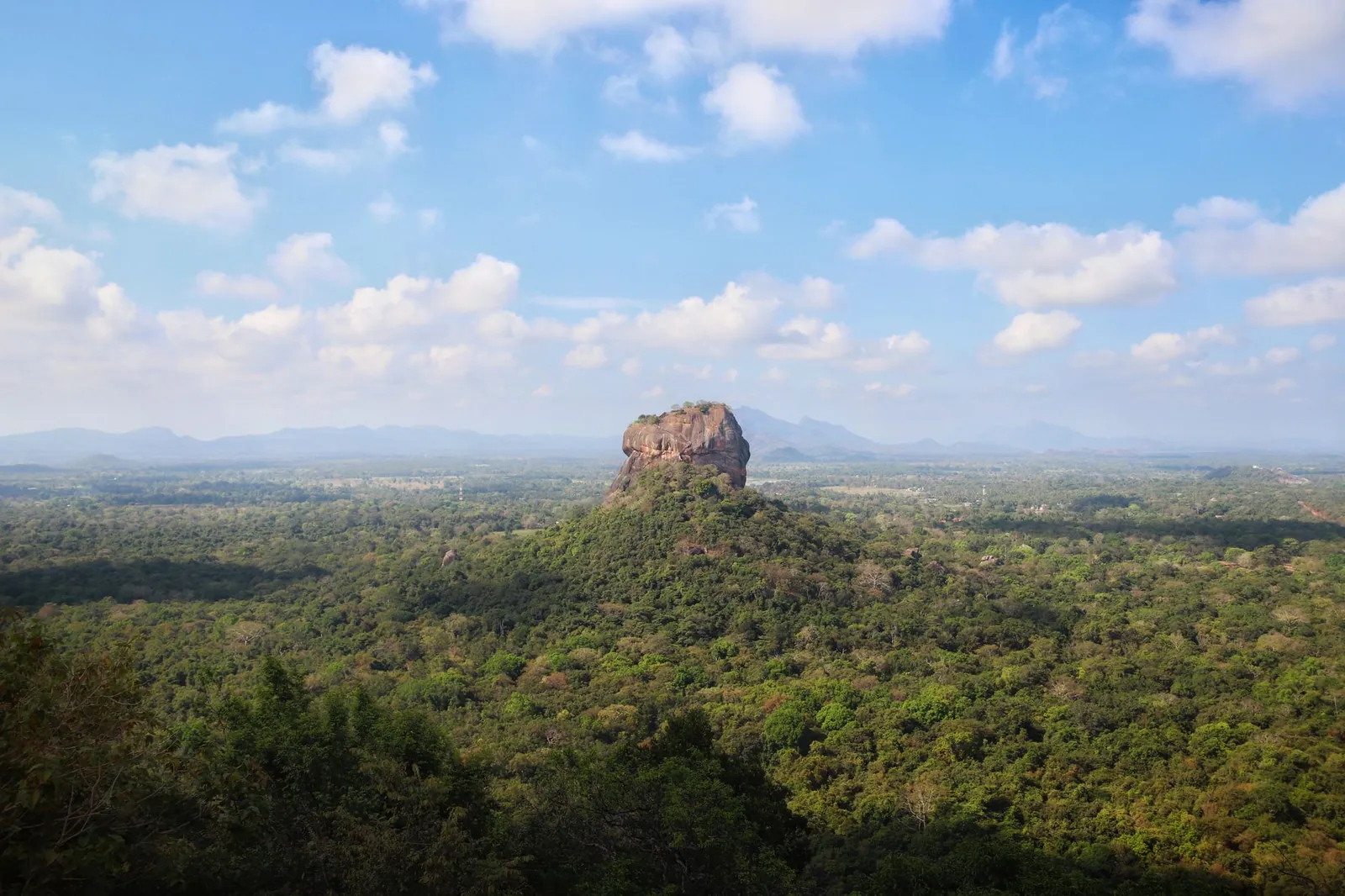 Breathtaking aerial view of the iconic Sigiriya Rock surrounded by lush forest in Sri Lanka.