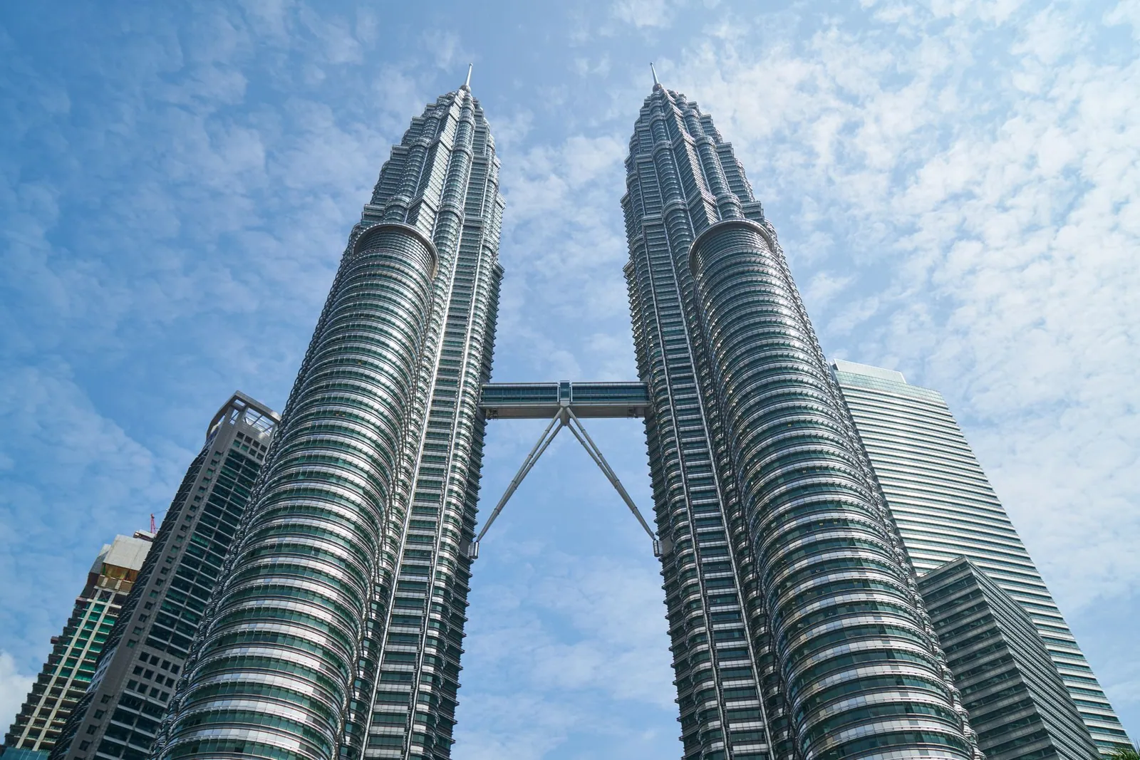 The iconic Petronas Twin Towers against a bright blue sky in Kuala Lumpur, Malaysia