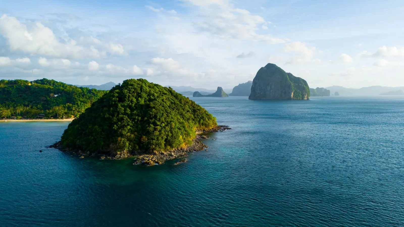 A breathtaking aerial view of the lush green islands of El Nido, Philippines, surrounded by crystal blue waters