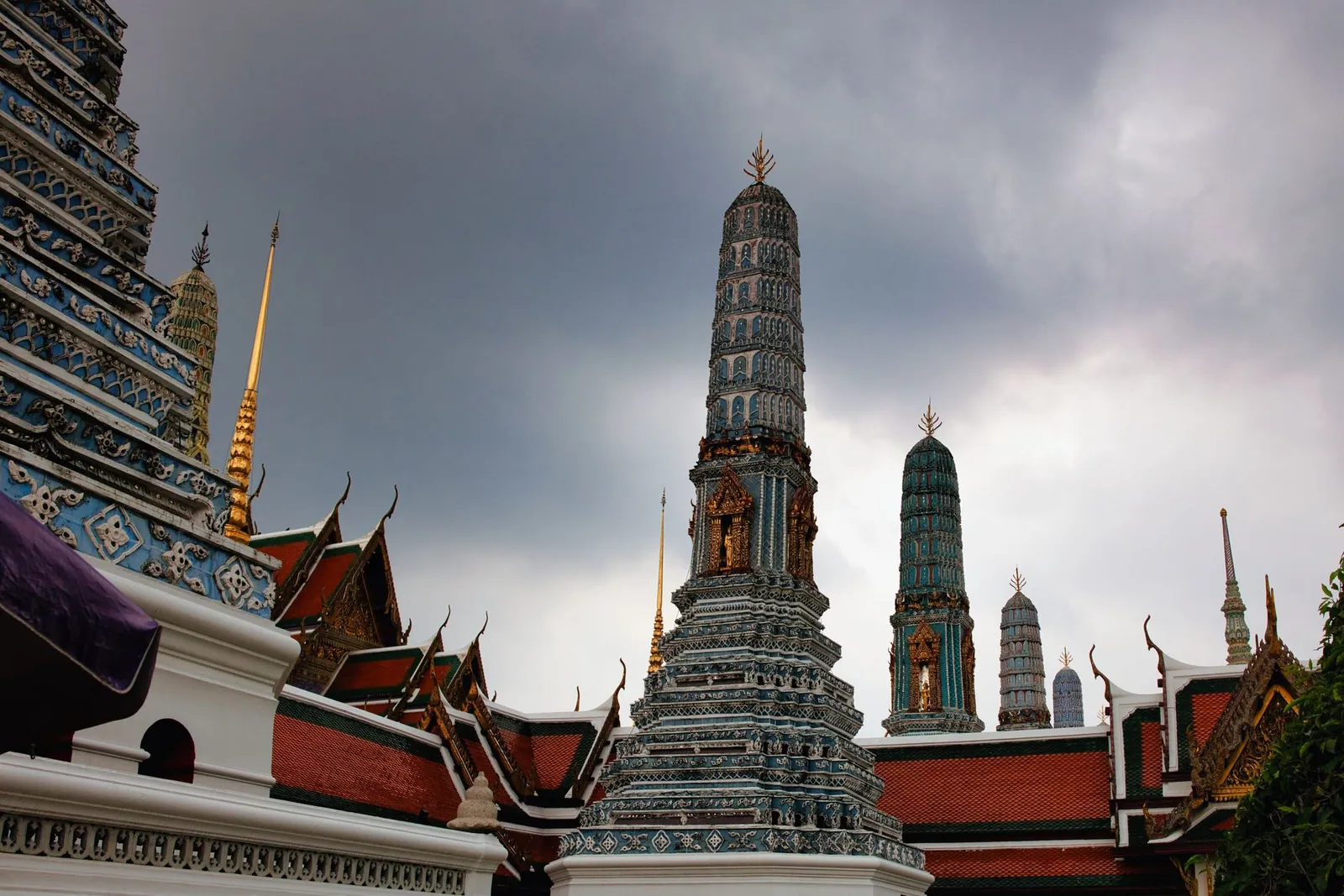 The spires of Wat Arun under a dramatic sky in Bangkok, Thailand