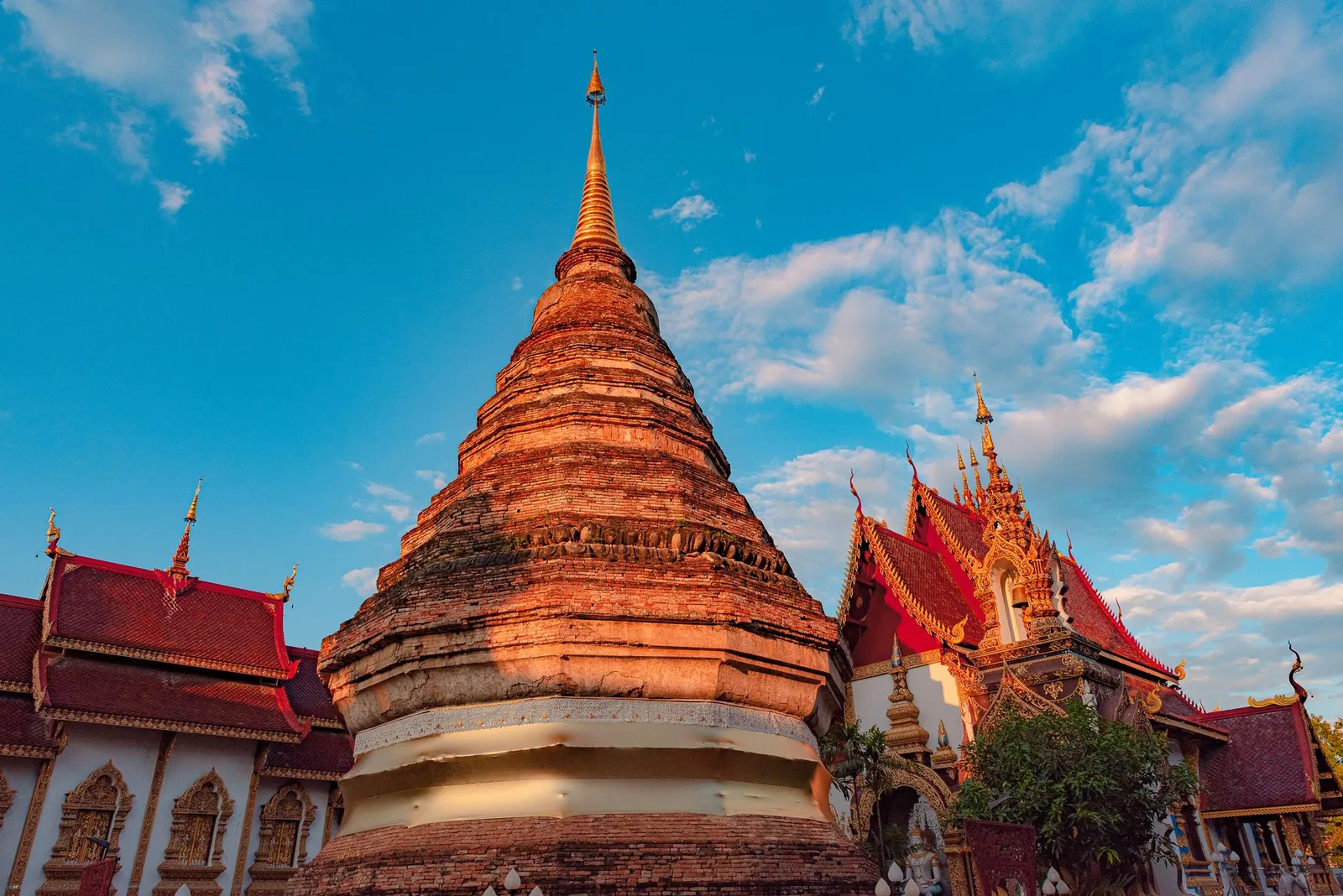 A traditional Buddhist temple against a bright blue sky in Chiang Mai, Thailand