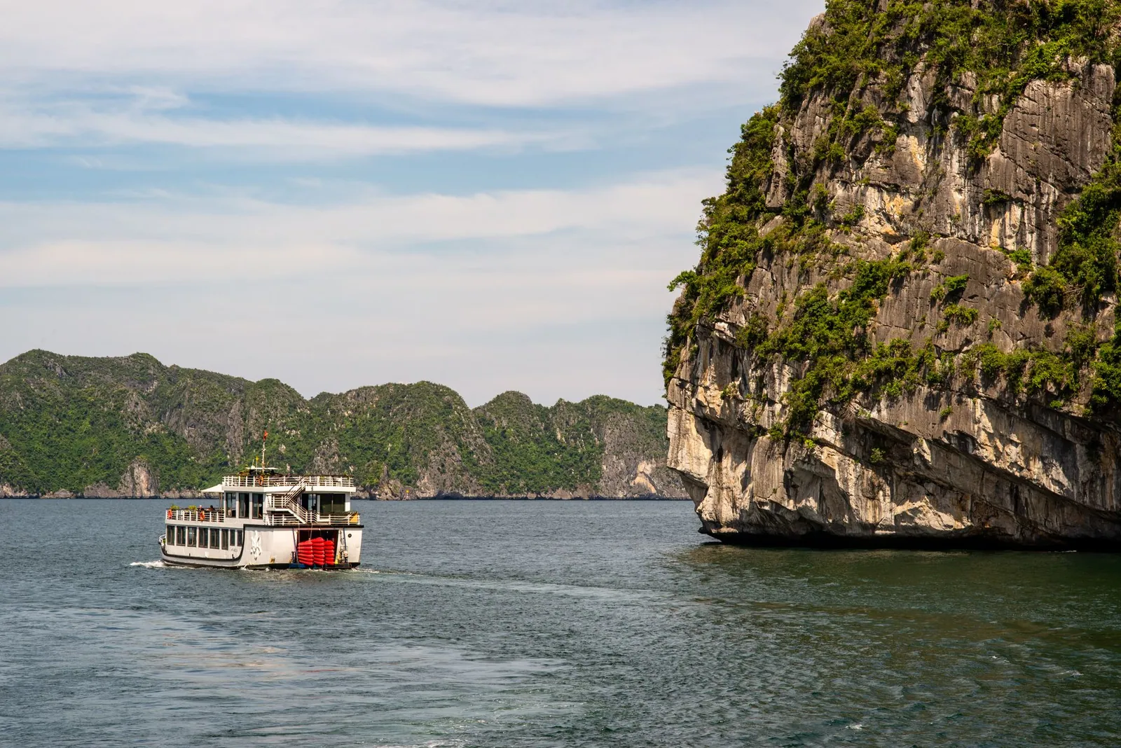 A boat sailing through limestone karsts in Vietnam