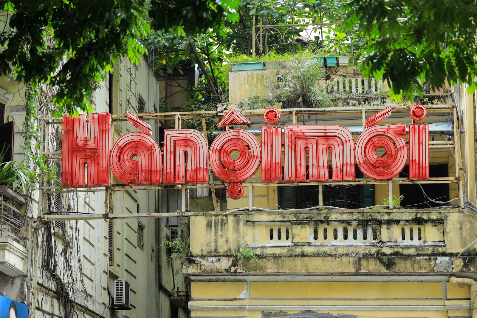 Neon sign on a vintage building in Vietnam showing older architecture