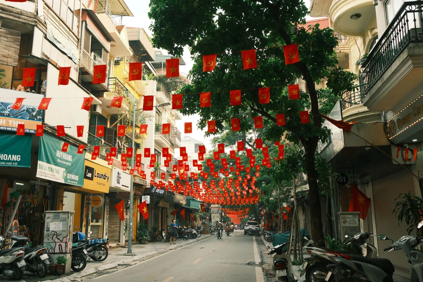Hanoi street festooned with Vietnamese flags and busy local life