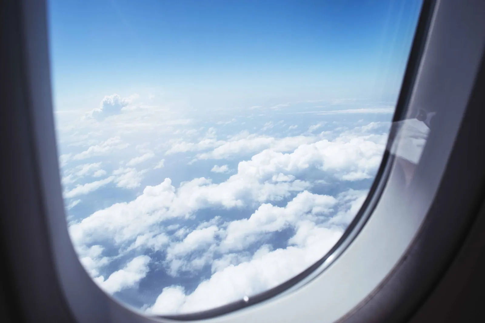 Breathtaking view of clouds and blue sky from a cabin window during flight
