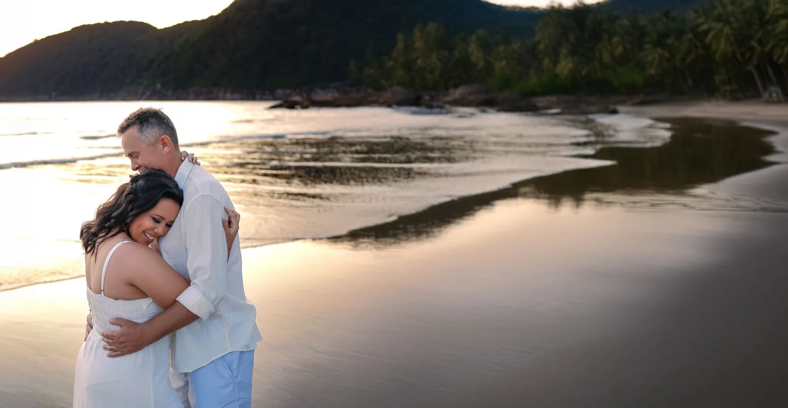 A loving couple embracing on a serene beach at sunset, capturing a moment of joy and romance