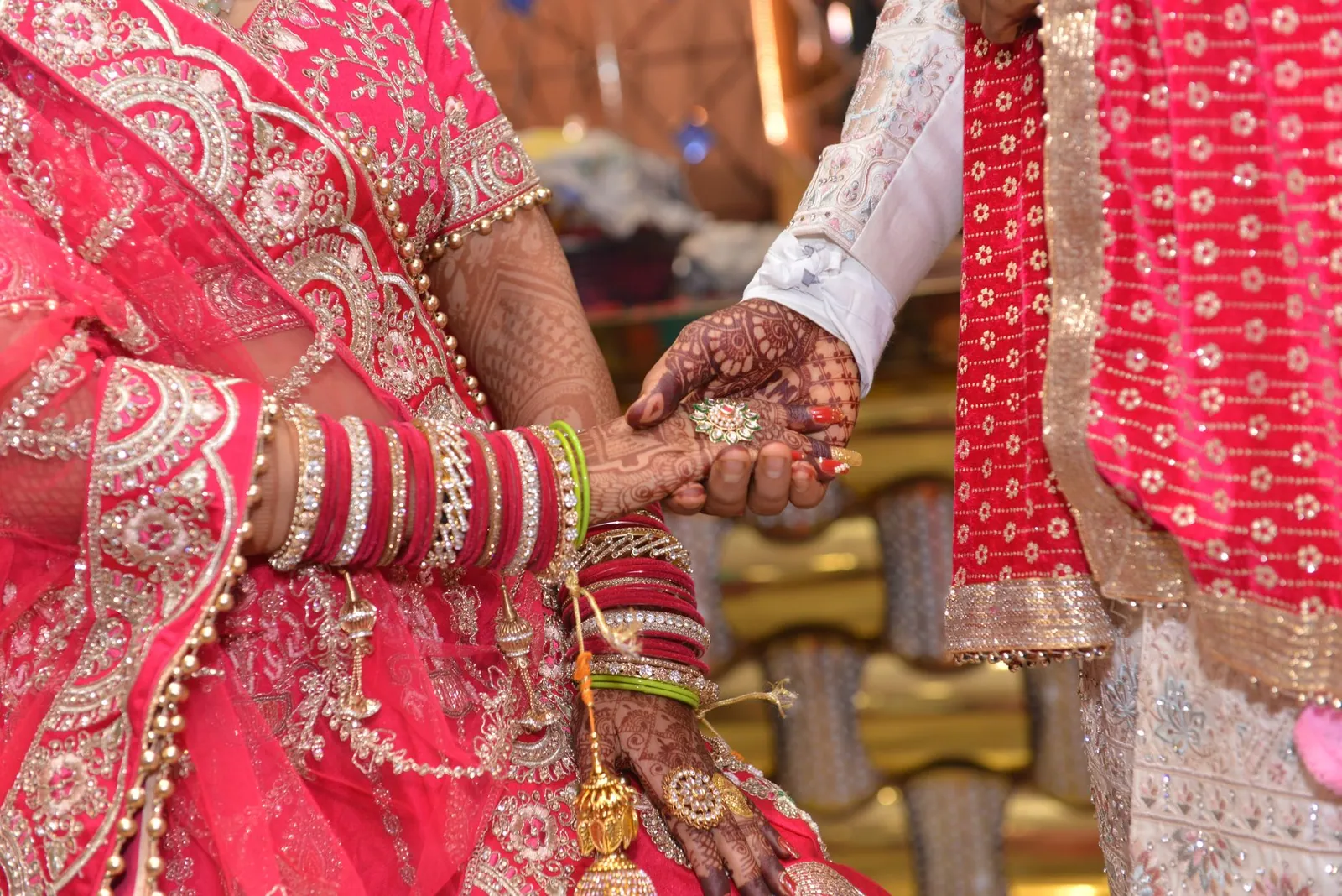 Close-up of an Indian wedding ceremony showing henna designs and traditional attire