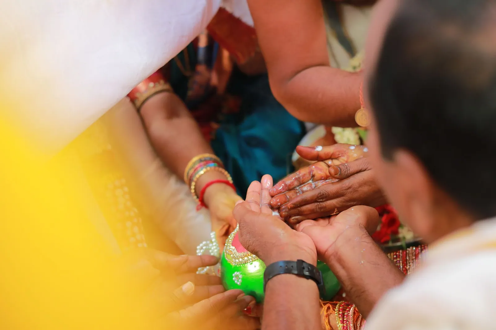 Close-up of hands during a traditional Indian wedding ritual, highlighting cultural traditions